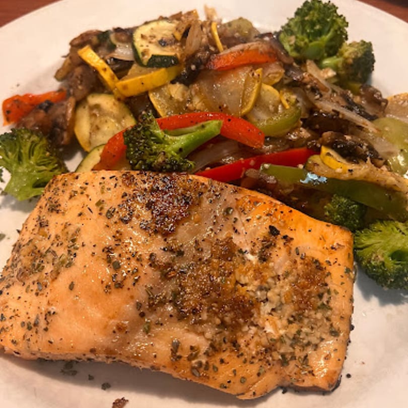 Seasoned salmon fillet with a side of roasted broccoli, zucchini, squash, and bell peppers.